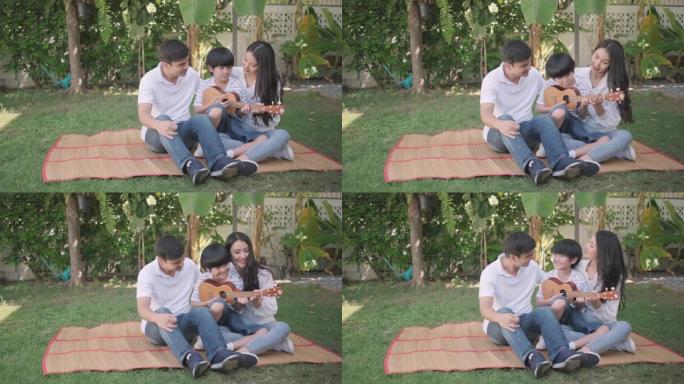 男孩和他的家人母亲和父亲在家庭花园里玩夏威夷四弦琴