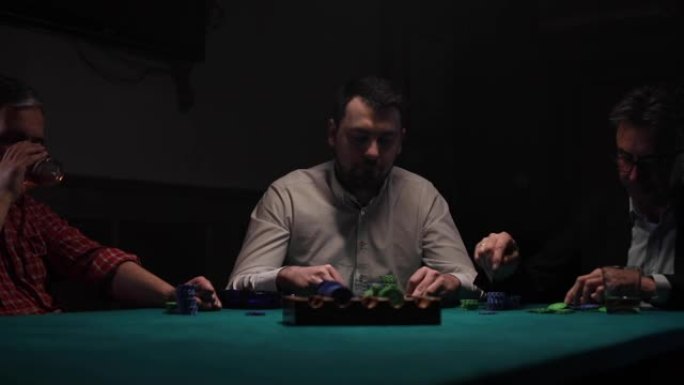 三个男人在黑暗的房间里玩扑克游戏