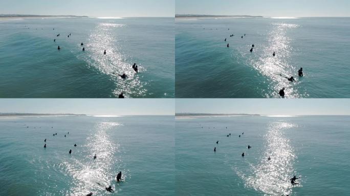 冲浪者在蓝色的大海中等待完美波浪的美丽鸟瞰图。
