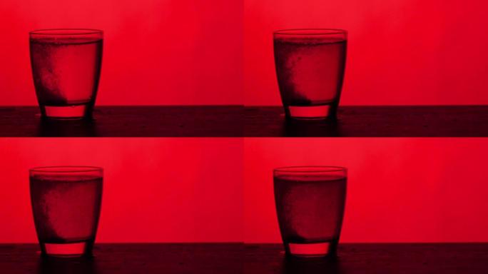 泡腾片溶解在一杯水-红色背景