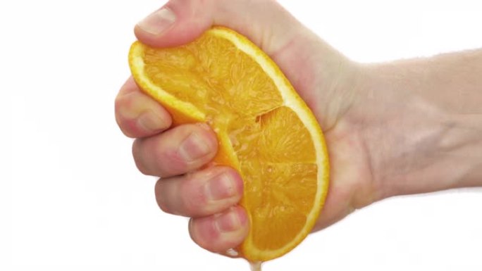 一个男人挤压一半成熟多汁的橘子的宏观镜头。柑橘汁滴下来。孤立，在白色背景上