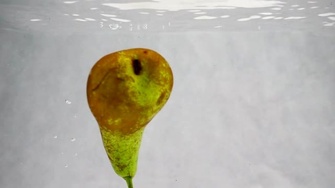 梨在水中以慢动作旋转的气泡旋转。