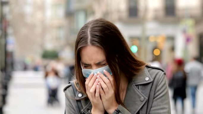 戴防护口罩在街上咳嗽的女人