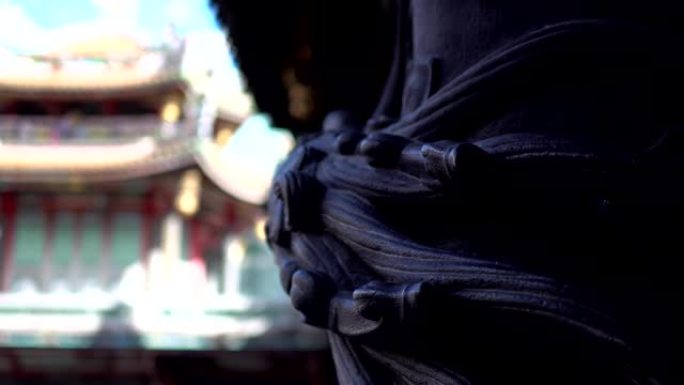 亚洲寺庙石柱上的龙雕。模糊的背景是神庙。