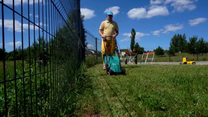 用电动割草机修剪后院草坪。万向节运动射击。