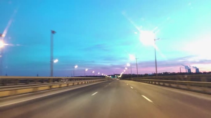 在黑暗视点的高速公路上驾驶汽车的时间推移。超级圈。黄昏日落路灯。晚上，摄像头在前面，挡风玻璃参考。晚