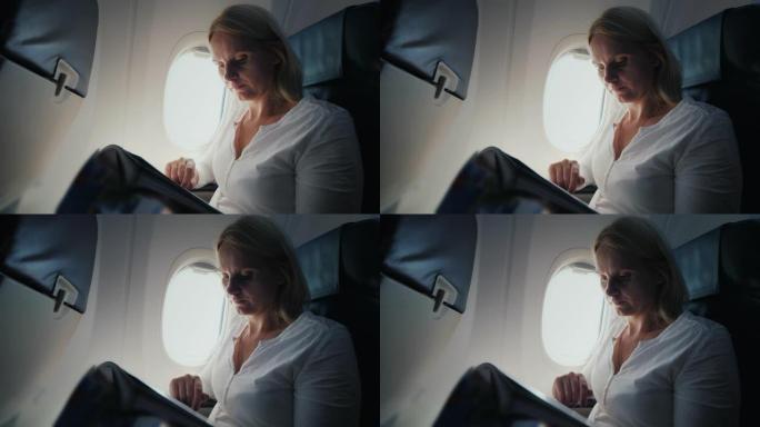 一名年轻女子正在飞机驾驶舱内阅读杂志。旅途中的舒适和娱乐