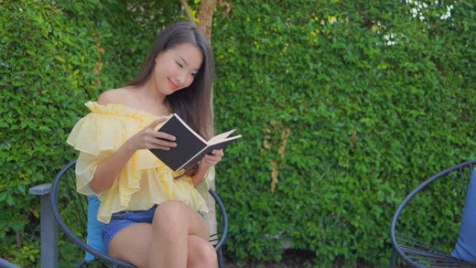 年轻的亚洲女性阅读户外自然景观的书