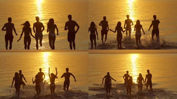 这群人在美丽的夕阳下跑进水中。慢动作