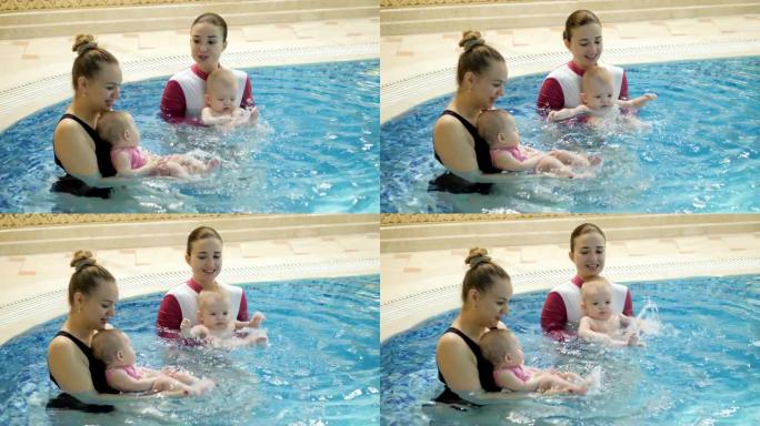 游泳课。母亲在游泳池里教新生婴儿游泳
