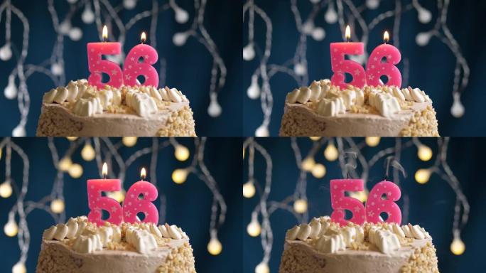 蓝色背景上有56号粉色蜡烛的生日蛋糕。蜡烛吹灭了。慢动作和特写视图