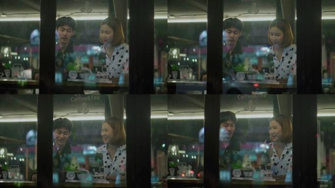 亚洲自由职业者夫妇晚上在咖啡馆使用笔记本电脑