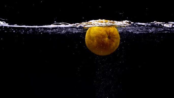 橙色以慢动作落在水中。孤立在黑色背景上。特写视图。用电影相机拍摄红龙，FHD，240fps