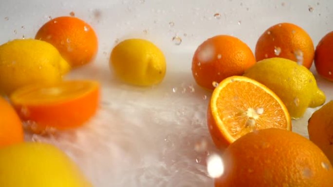 多汁的橘子掉入水中。慢动作。