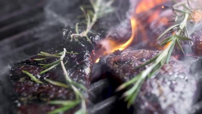 大理石牛排。用高温油炸。框架中的火焰和烟雾。周末烧烤。肉是香的百里香。相机移动，改变焦点。特写，慢动