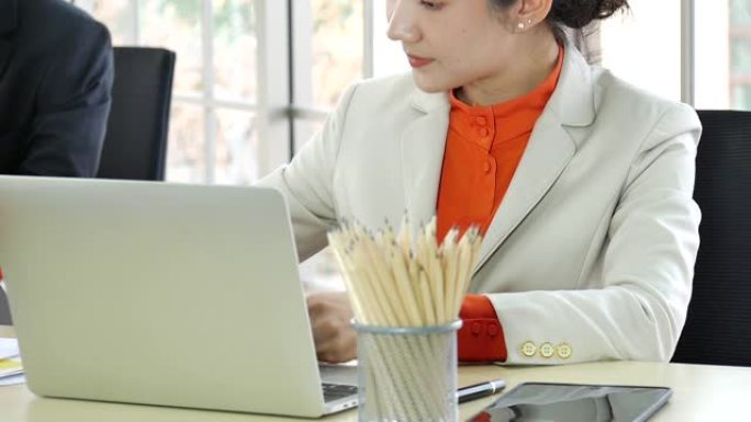 泰国商人女人正装套装坐在复印空间上的电脑笔记本