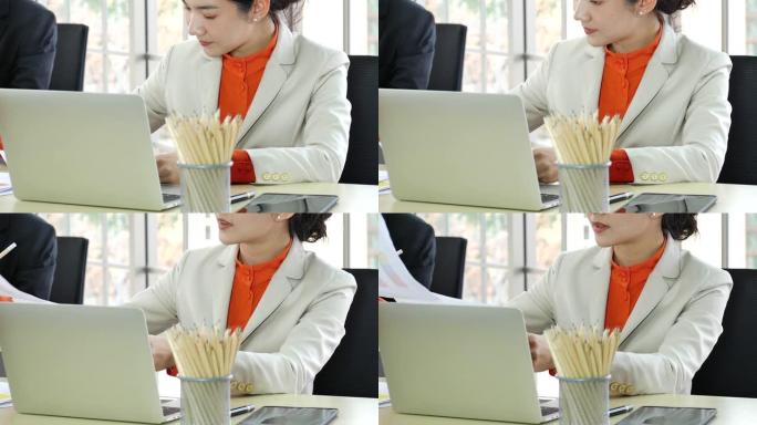 泰国商人女人正装套装坐在复印空间上的电脑笔记本