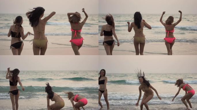 4k组快乐年轻美丽的亚洲女性朋友穿着比基尼泳装在海滩上奔跑，在夏天的日落时分在海水中跳跃和玩耍。快乐