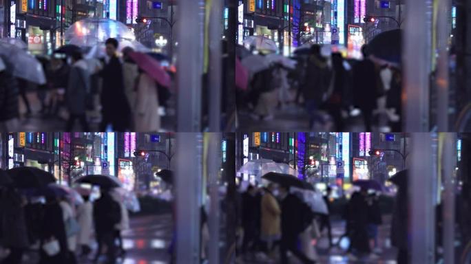 晚上在新宿东京下雨天在十字路口散步的人