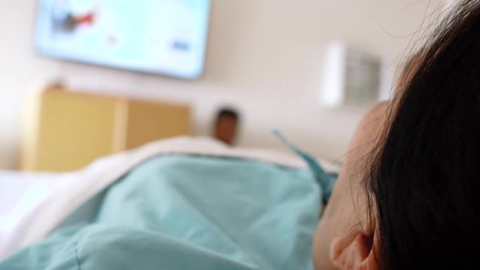 在医院模糊的豪华贵宾室背景下，直接将静脉输液的患者手关闭。住院的亚洲妇女。