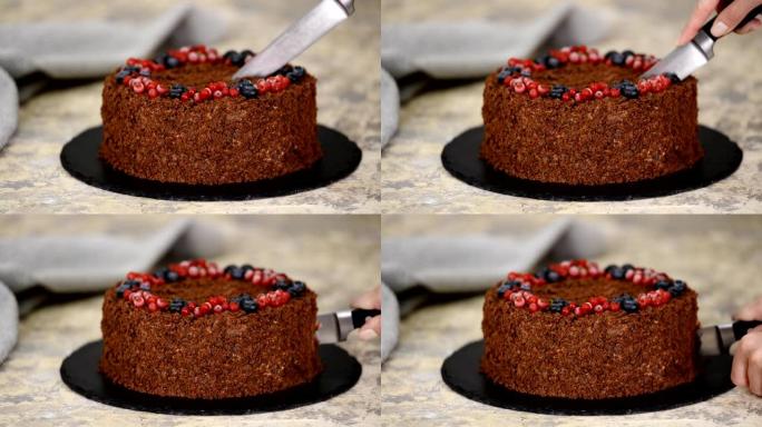 女人用刀切俄罗斯巧克力蛋糕拿破仑。浆果酥皮巧克力拿破仑蛋糕。
