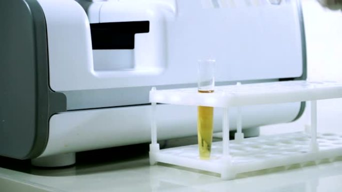 男性实验室工作人员在现代设备下进行尿液样本。高清