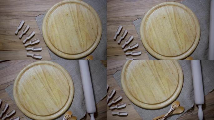 木制厨房配件: 混凝土背景上的盘子、面杖、木板、抹刀。顶视图。厨具。