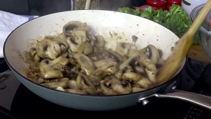 在煎锅特写镜头中搅拌蘑菇