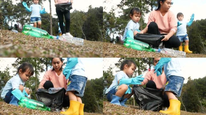 带着孩子在森林里收集垃圾的志愿者家庭。小女孩和戴着手套的母亲从公园的草地上捡起一个塑料瓶。保存环境和