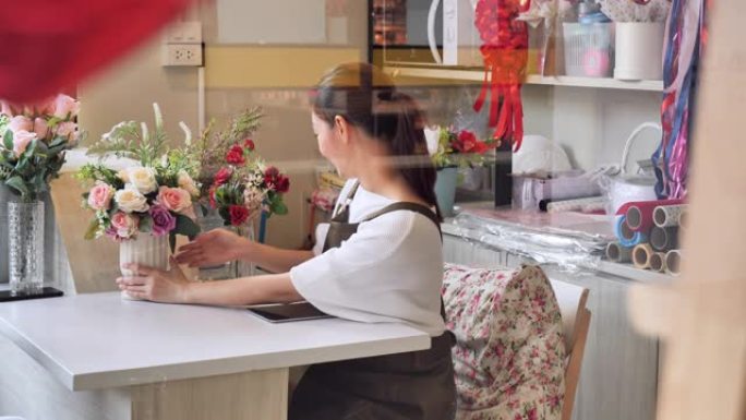 花店主亚洲女人接到订单准备店内销售，一个日本女人与专业花店，小企业概念。