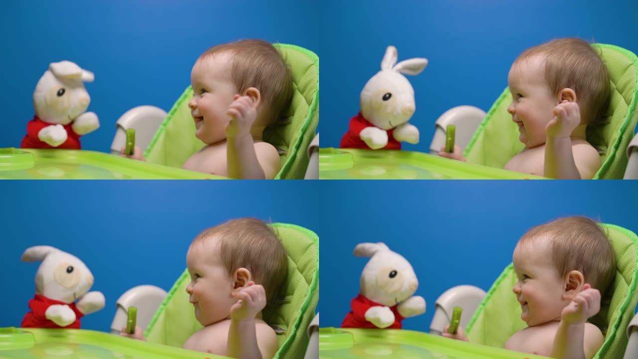 可爱的孩子宝宝吃绿色新鲜芹菜棒玩兔子娃娃