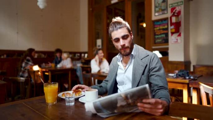 时髦的男人喝咖啡和看报纸