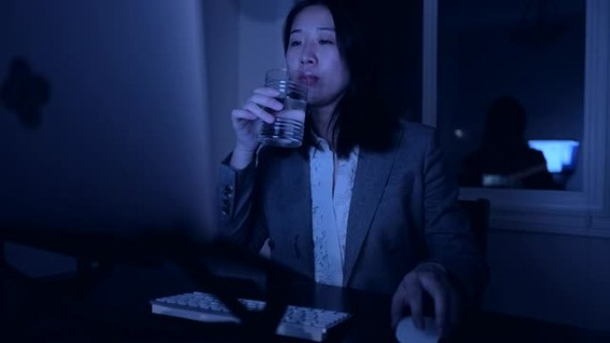 年轻的亚洲妇女在家工作到很晚