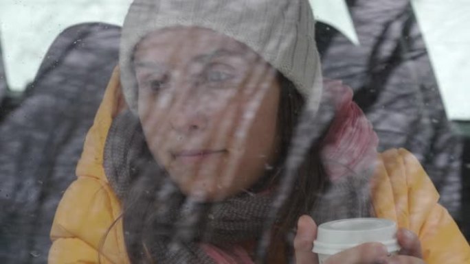 汽车视点。第一次降雪后，在雪地里开车时喝咖啡休息。滑雪胜地的寒假。乘客从车窗向外看。