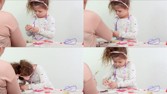 小女孩用白色和粉红色的纸泡沫制作独角兽工艺。