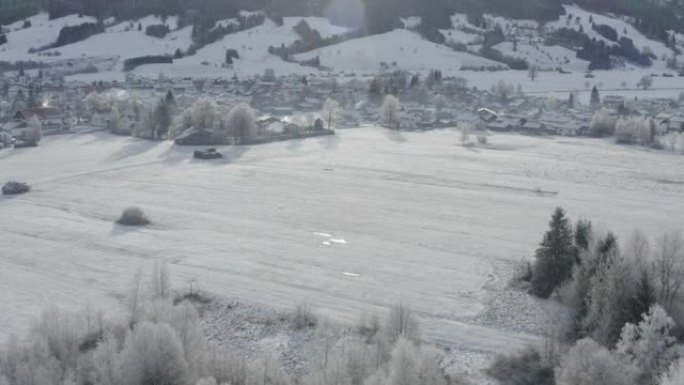 冬季日出时在山脚下的德国小城鸟瞰图，德国哈勒布勒奇市，巴伐利亚，树枝上覆盖着白霜，天气晴朗