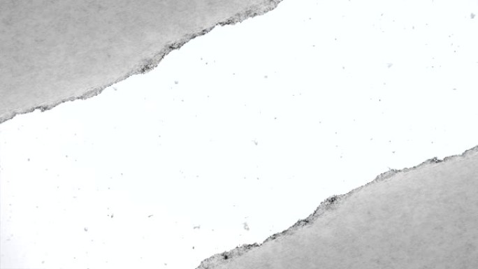 缓慢落下的雪的创意慢动作视频，可以通过旧复古垃圾老式纸边缘撕裂的孔看到。