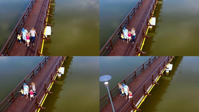 一家人一起在桥上散步的鸟瞰图。爸爸妈妈带着儿子和女儿