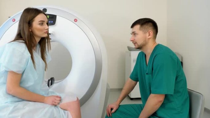医生和年轻的女病人谈话。美女正在现代医院接受MRI或ct扫描。4K