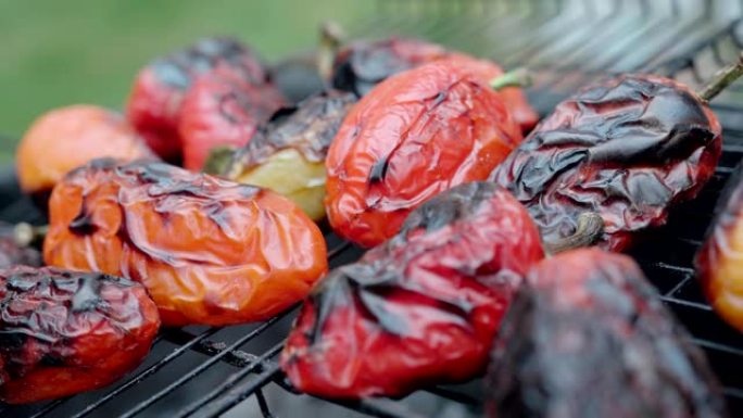 户外烤架上的辣椒特写镜头显示火焰和烟雾。蔬菜烤架。烧烤
