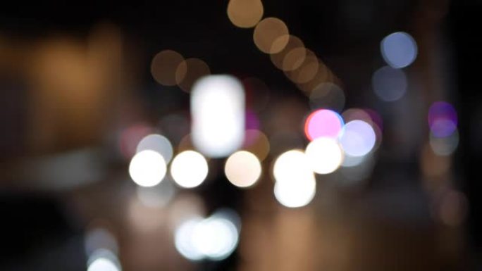 美丽闪闪发光的bokeh在黑暗模糊的背景在夜晚。城市街道交通拥堵时，圆形五颜六色的散景从车灯中闪耀。