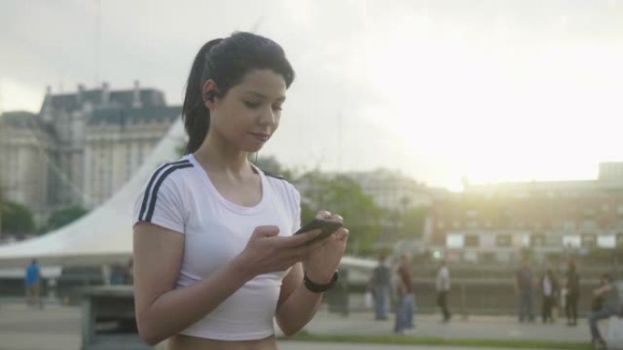 年轻的拉丁美洲妇女在健身过程中使用智能手机