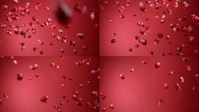 成熟石榴的多汁颗粒在红色背景上斜向下降