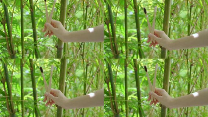 一个女人的手展示了两把用竹子制成的木制牙刷。环保零废竹制品的概念