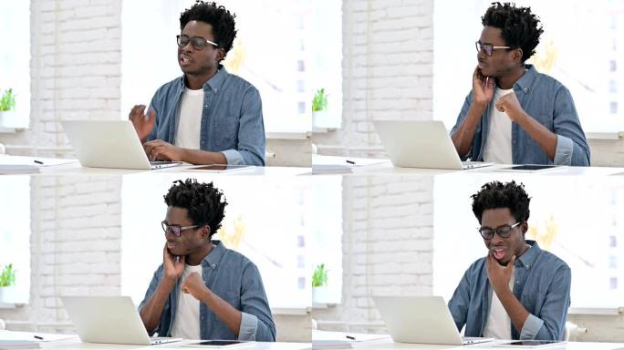 年轻的非洲男子在笔记本电脑上牙痛