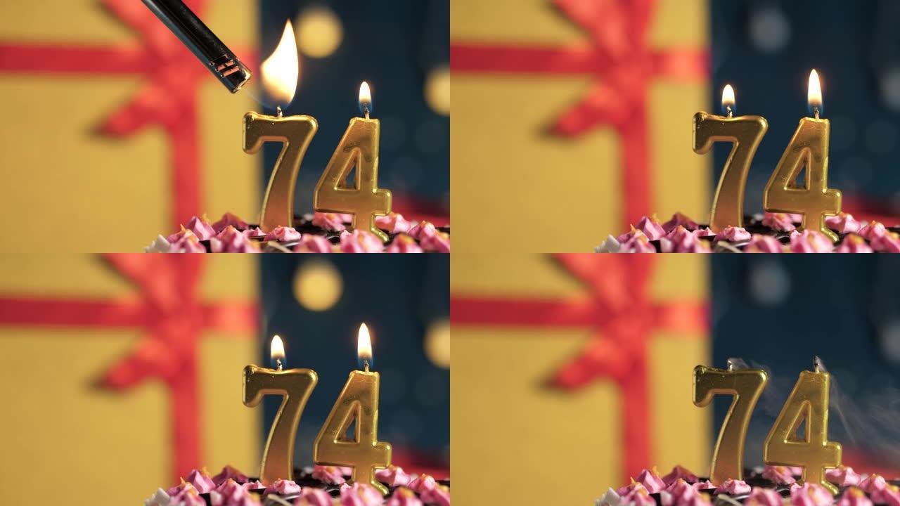 生日蛋糕74号点火器燃烧的金色蜡烛，蓝色背景礼物黄色盒子用红丝带绑起来。特写和慢动作