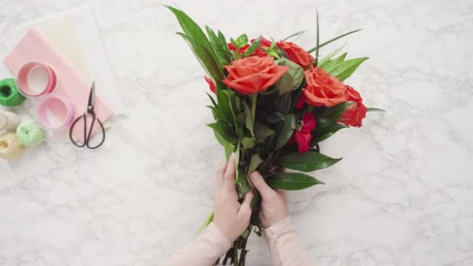 花店将红玫瑰包裹成美丽的花束。