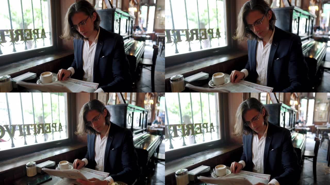 英俊的商人在咖啡馆看报纸