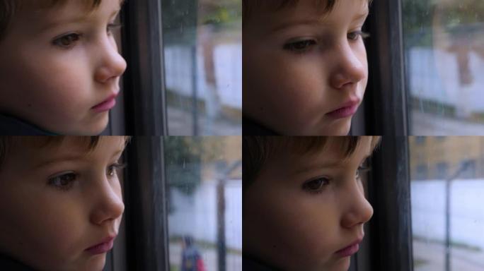 孩子透过窗户看。一个孩子在火车上向窗外看的特写镜头。特写后侧视图。坐火车旅行。这个男孩看着跑步的风景