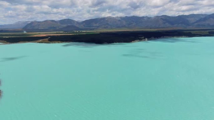 沿着新西兰南岛的高山湖泊普卡基湖沿岸的8号国道的令人惊叹的空中高角度无人机视图。水以其鲜明的鲜艳色彩